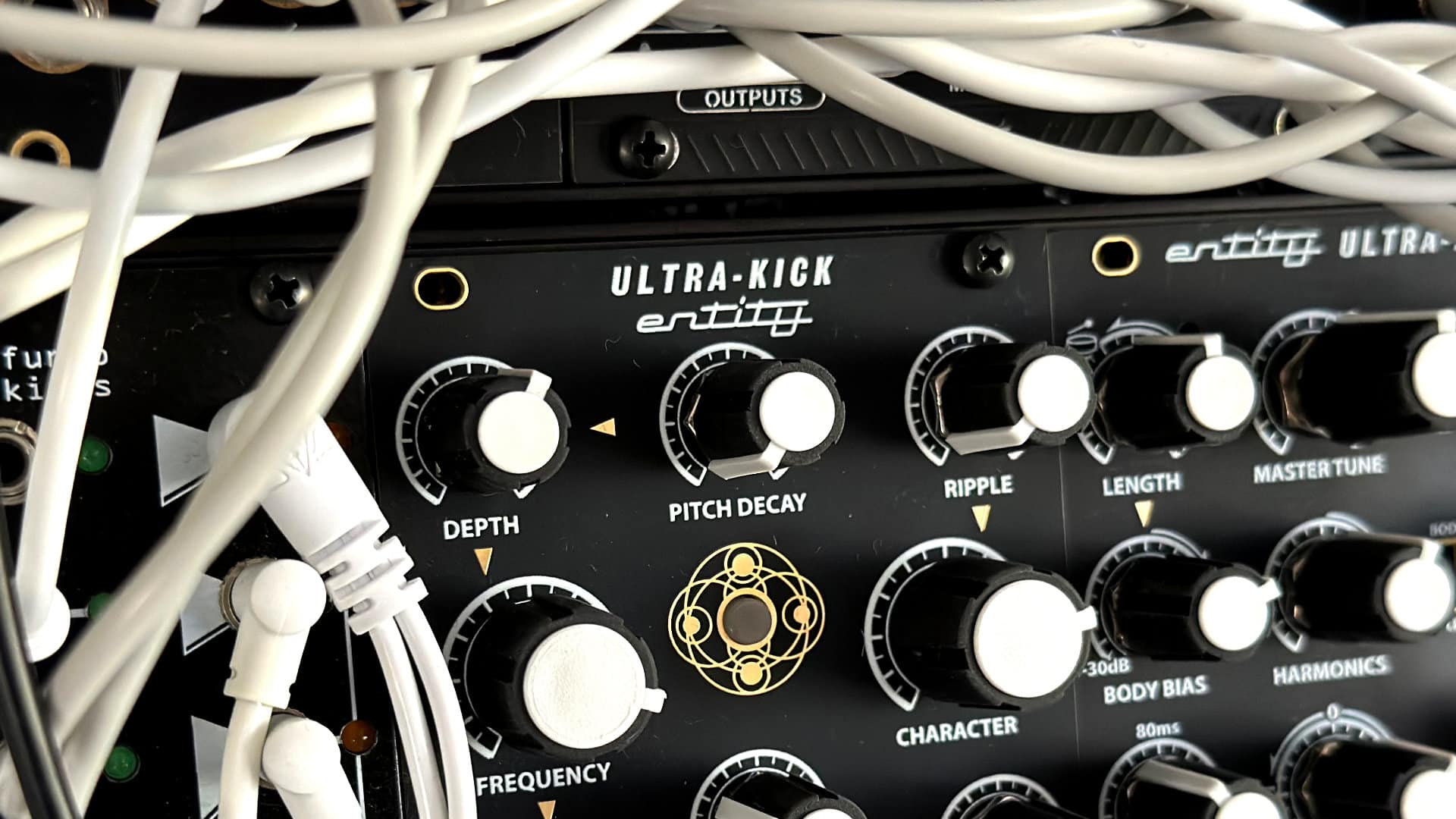 Close-up of the SSF Ultra-Kick module with large black knobs and white patch cables