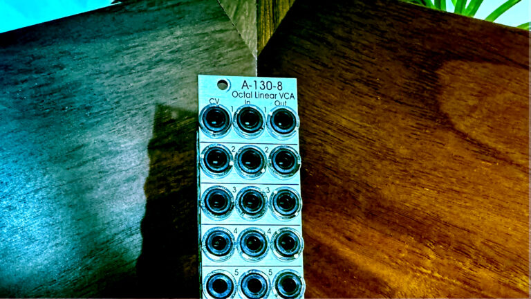 Doepfer A-130-8 module with a grid of jacks lying on a wooden surface
