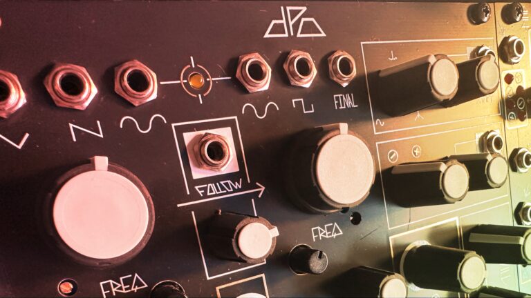 Close-up of a Eurorack panel with a large pink knob and jacks in warm light