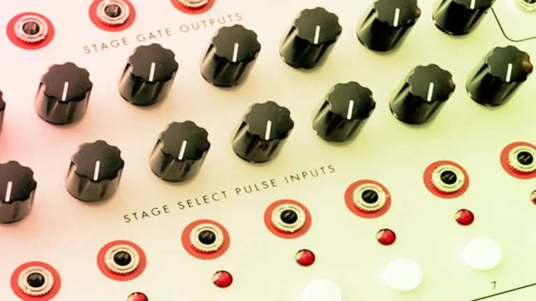 Close-up of black knobs and red jacks on a cream panel labeled Stage Gate Pulse Inputs